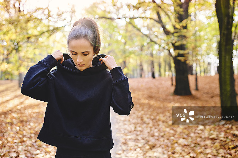 秋天森林里年轻的女性慢跑者图片素材