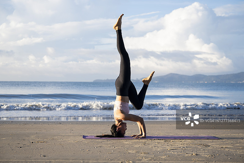 在海滩上练习瑜伽的女人图片素材