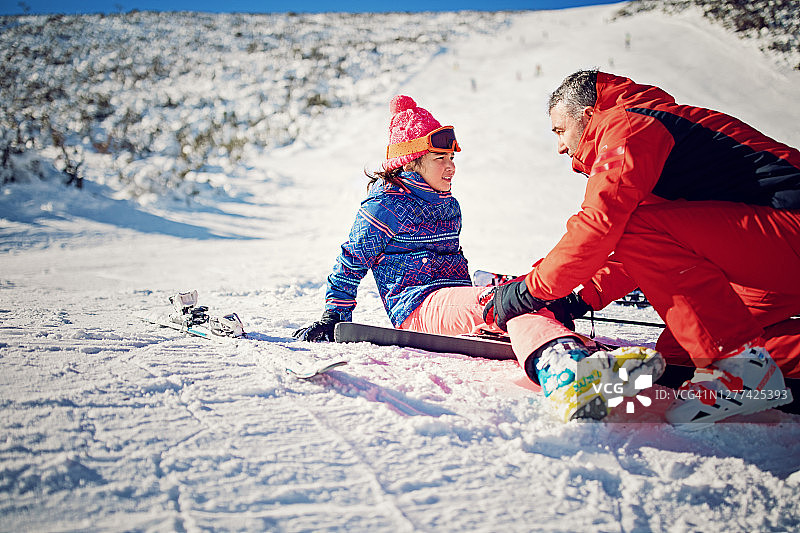 滑雪巡逻队正在帮助滑雪坡上受伤的女孩图片素材