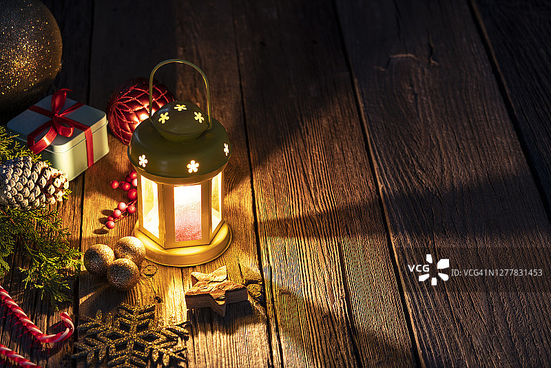 圣诞彩灯、烛光、木头上的礼物和小玩意图片素材