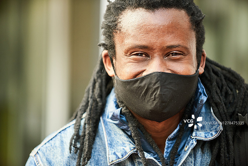 一名男子站在城市街道上，戴着防护口罩图片素材