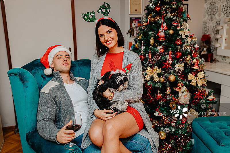 男朋友和女朋友与约克夏梗狗庆祝圣诞节图片素材