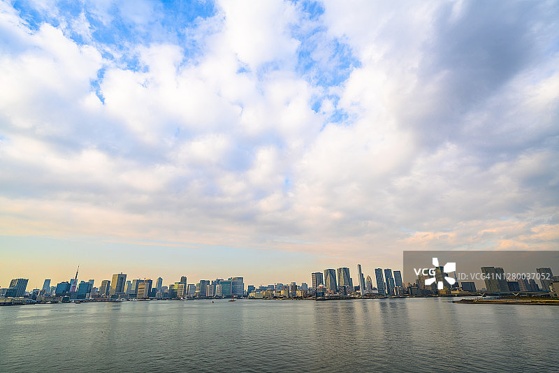 一排高层建筑矗立在东京湾，这是在日本东京的彩虹桥上拍摄的。图片素材
