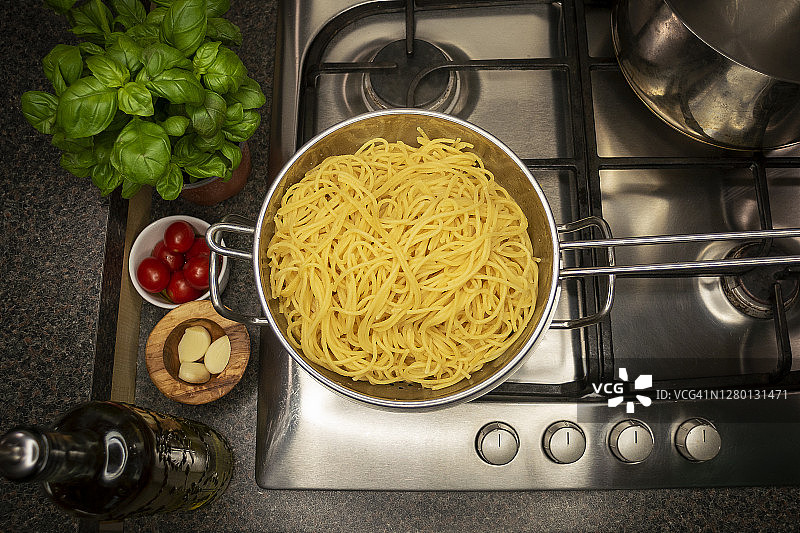 煮熟的意大利面在平底锅上漏水。图片素材