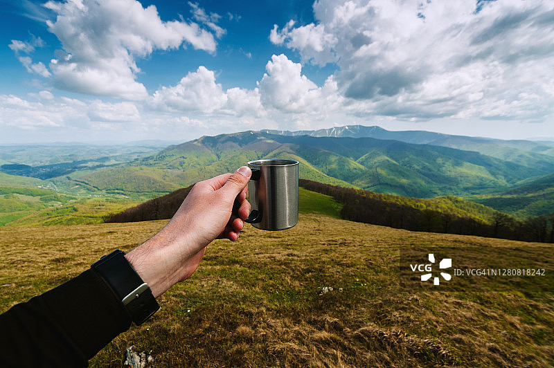 手握咖啡杯对着山全景图片素材