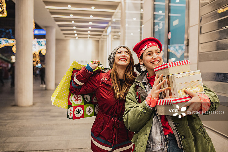 两个快乐的女性朋友在圣诞购物图片素材