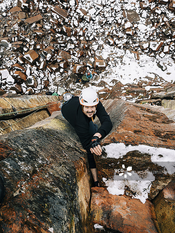 在不列颠哥伦比亚省沙漠内部，一名男性攀岩者在阿伯丁石柱的攀爬中达到了顶峰，此时地面上正迎来本季的第一场雪图片素材