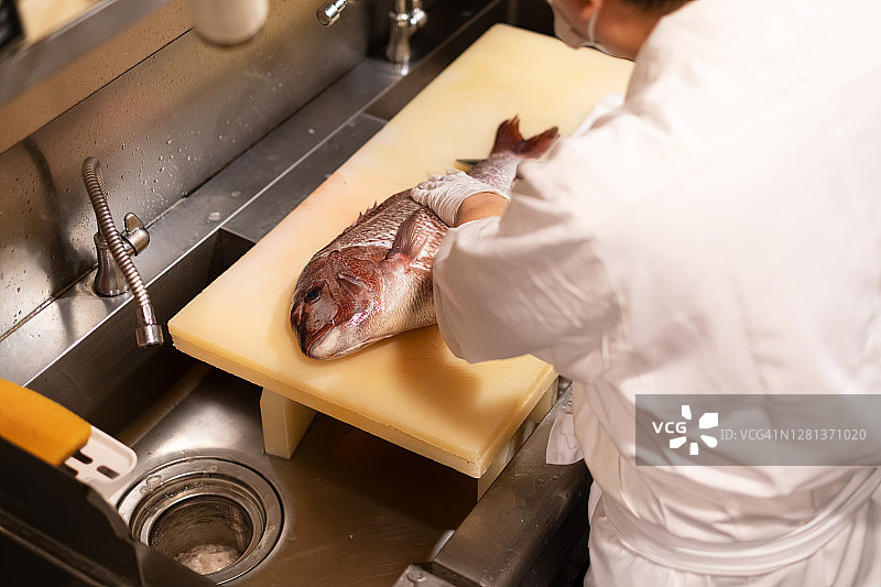 厨师在日本餐厅厨房烹饪海鲷的特写图片素材