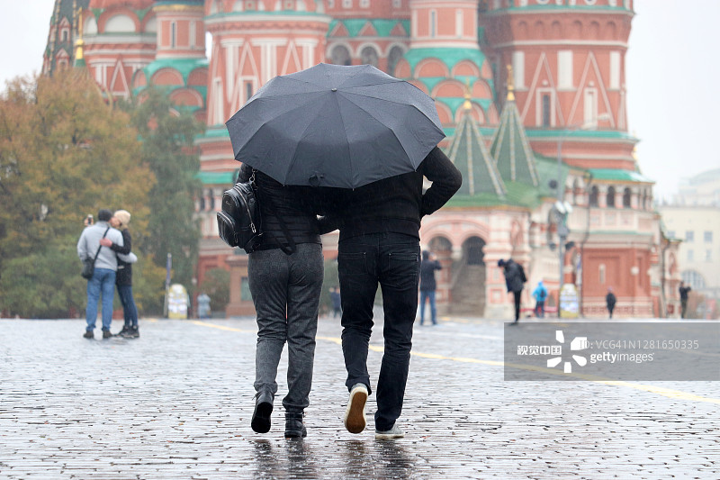 雨中莫斯科，夫妇撑着伞在红场上散步图片素材