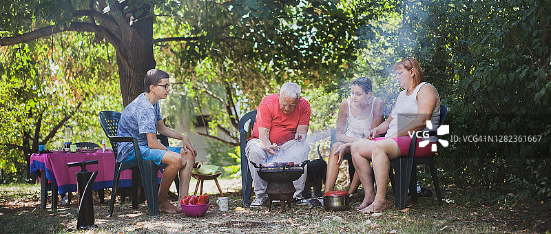 大家庭在后院享受准备烧烤的乐趣图片素材