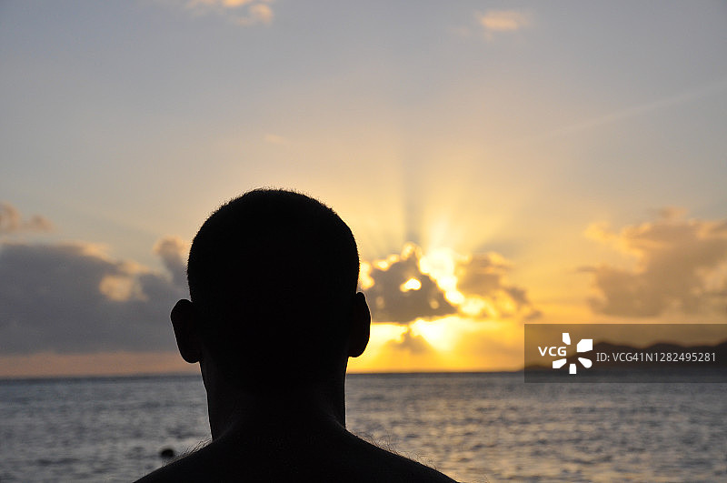 日落时，一个头领的剪影与大海在一起图片素材