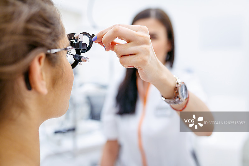 女眼科医生用光度计检查病人视力图片素材