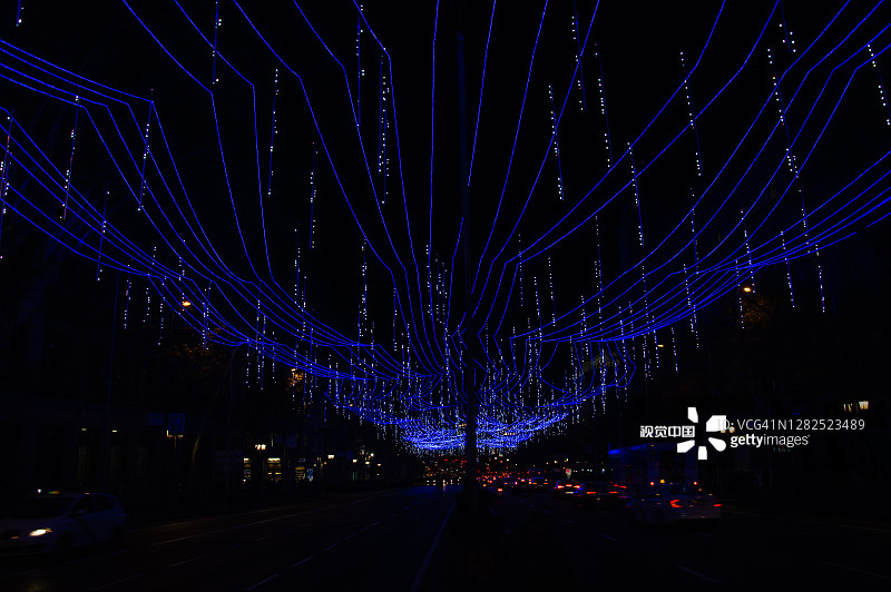 马德里街道上的圣诞彩灯。西班牙市中心的蓝色灯光和巨大的圣诞树图片素材
