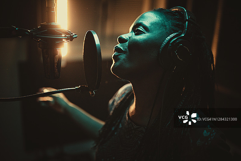 一位非裔美国女歌手在录音室录制歌曲图片素材