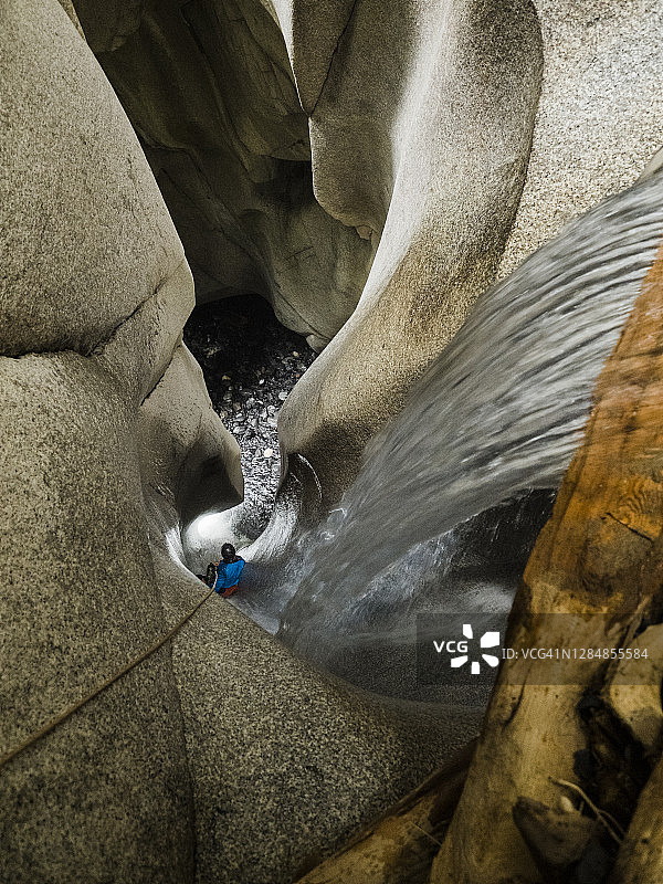 在不列颠哥伦比亚省攀峡时，女性从峡谷深处的瀑布中滑下图片素材