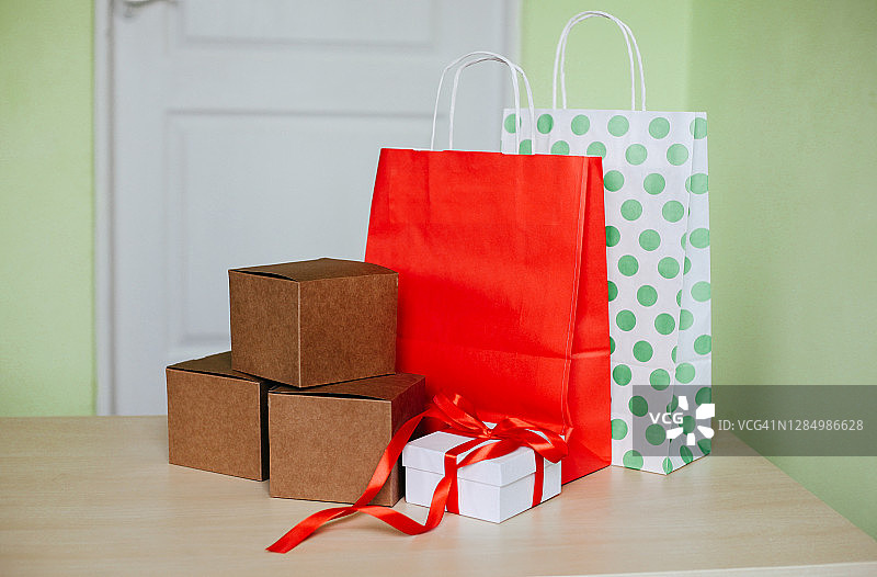 纸质购物袋和盒子在家里。黑色星期五的概念，网络星期一，网上购物，礼物和包装。图片素材
