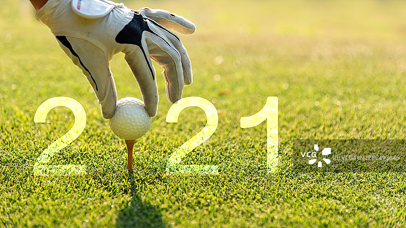 近手高尔夫球手女子高尔夫球新年快乐2021在绿色高尔夫新的健康。副本的空间。健康假日理念。图片素材