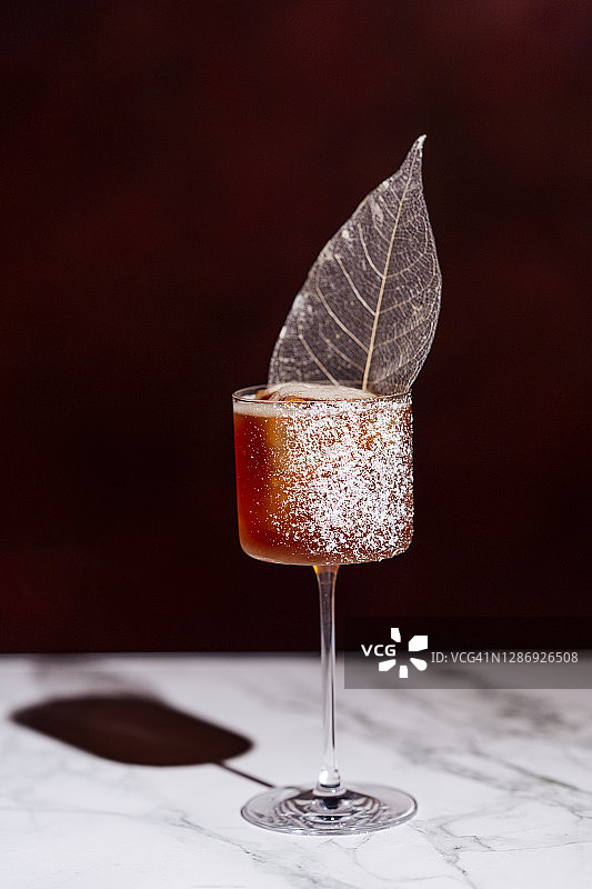 马提尼杯中装饰有冰叶的鸡尾酒图片素材