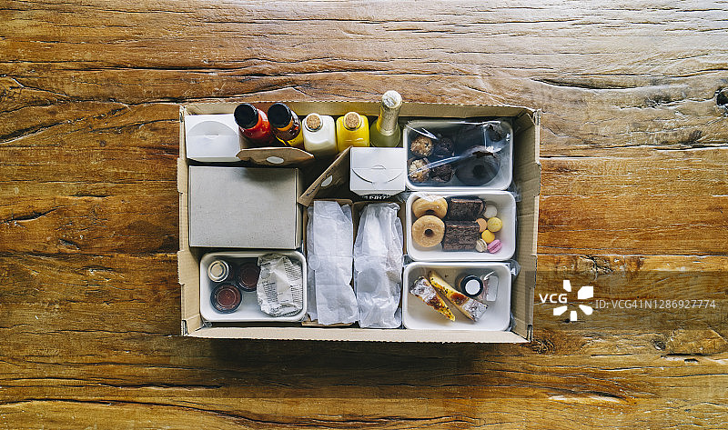 在餐厅的木桌上，食物包装在纸板箱里图片素材