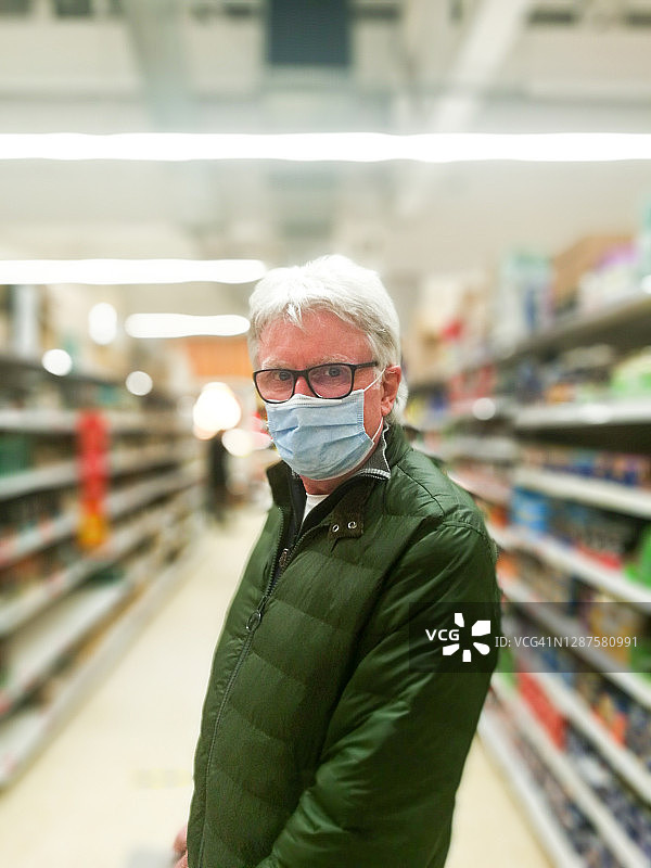 戴着防护口罩的老人在超市购物图片素材