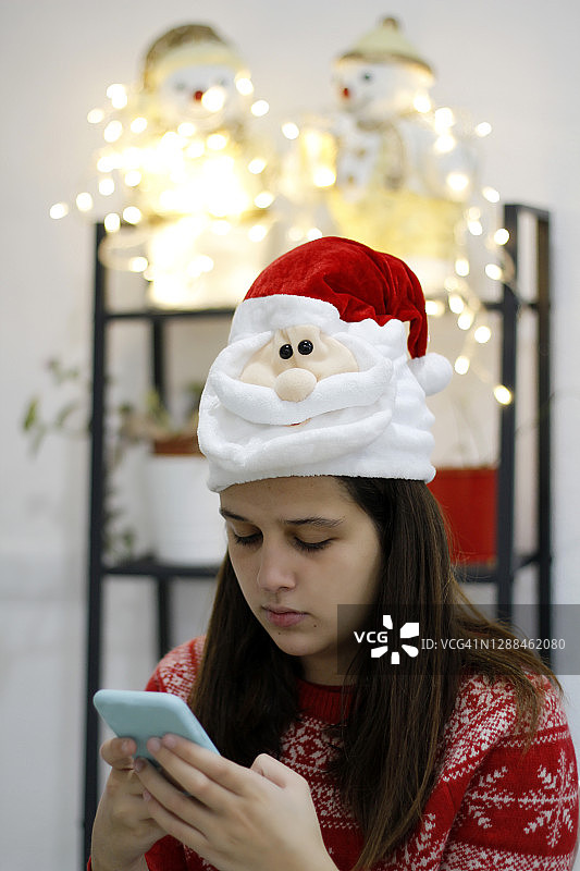 少女在圣诞节期间用智能手机视频聊天图片素材