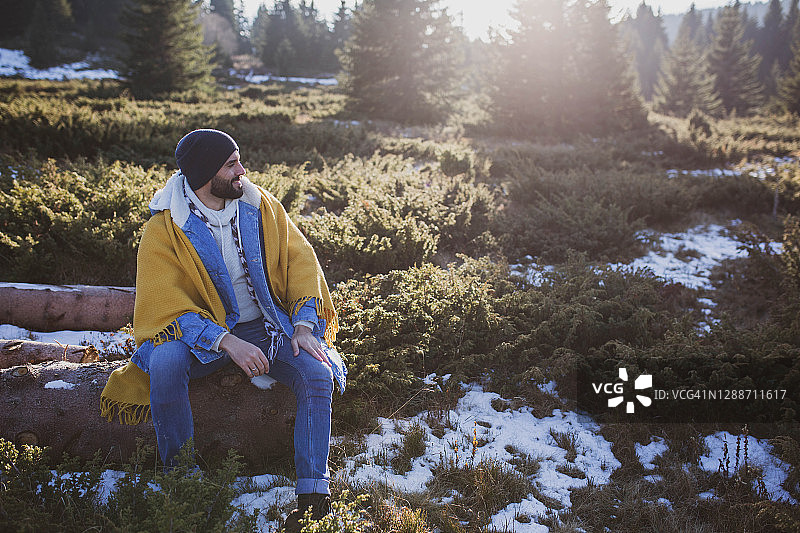 英俊的男人喜欢在寒冷的冬天散步在山上的新鲜空气和美丽的景色图片素材