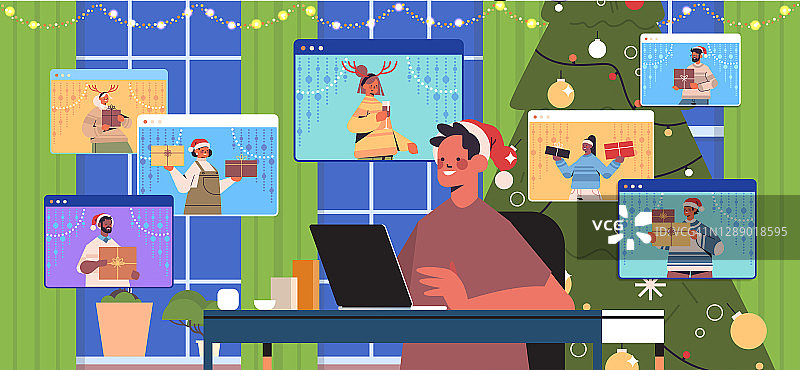 小伙子使用笔记本电脑与朋友讨论在网页浏览器Windows圣诞新年节日快乐庆祝活动图片素材