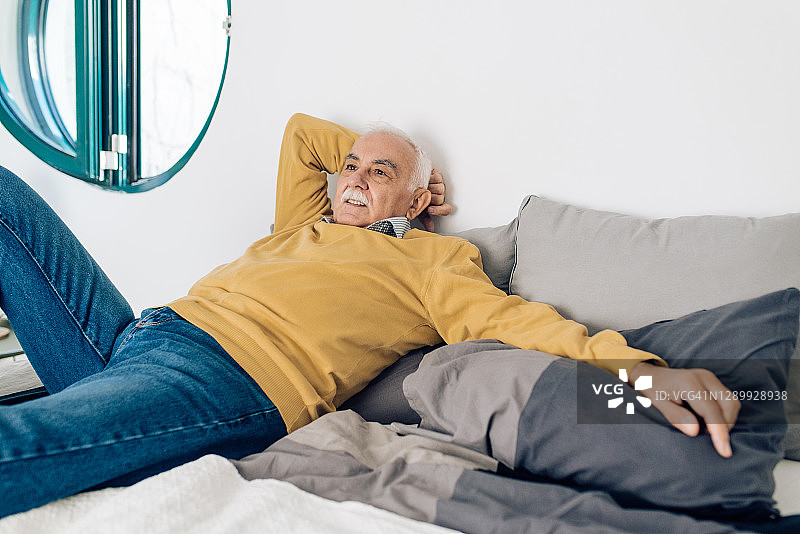 一个老人躺在床上享受图片素材