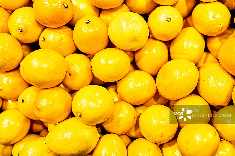 熟黄柠檬特写背景或纹理。柠檬收获，许多黄色的柠檬。图片素材