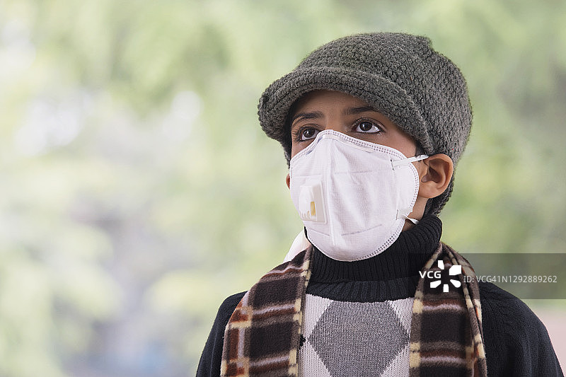 小男孩戴着防污染口罩，穿着冬天的衣服。(儿童)图片素材