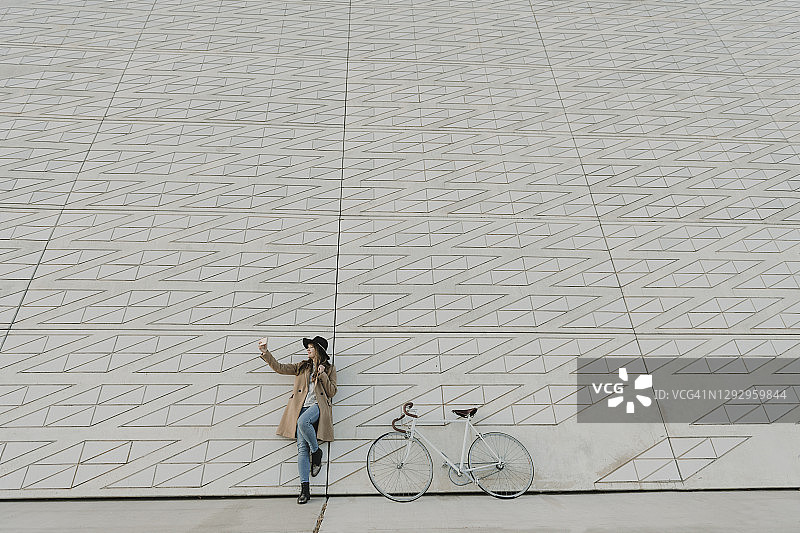年轻时髦的女人在自行车旁自拍图片素材