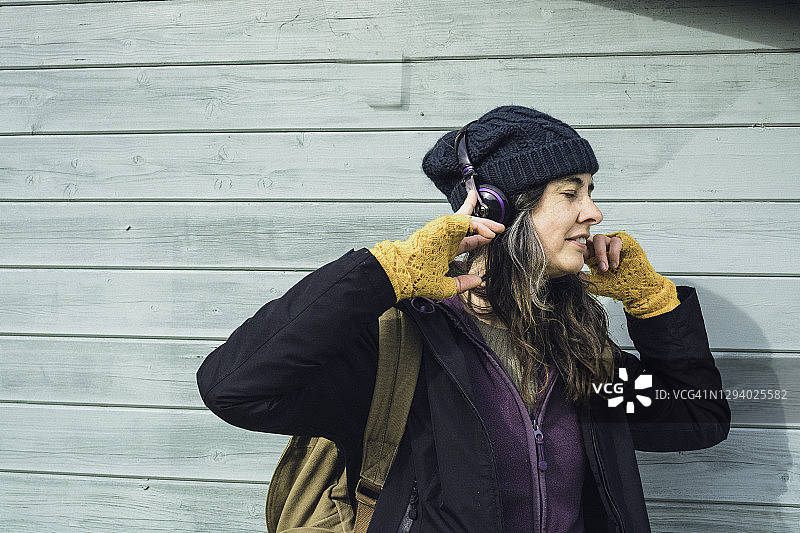 成年女性戴着耳机听音乐图片素材