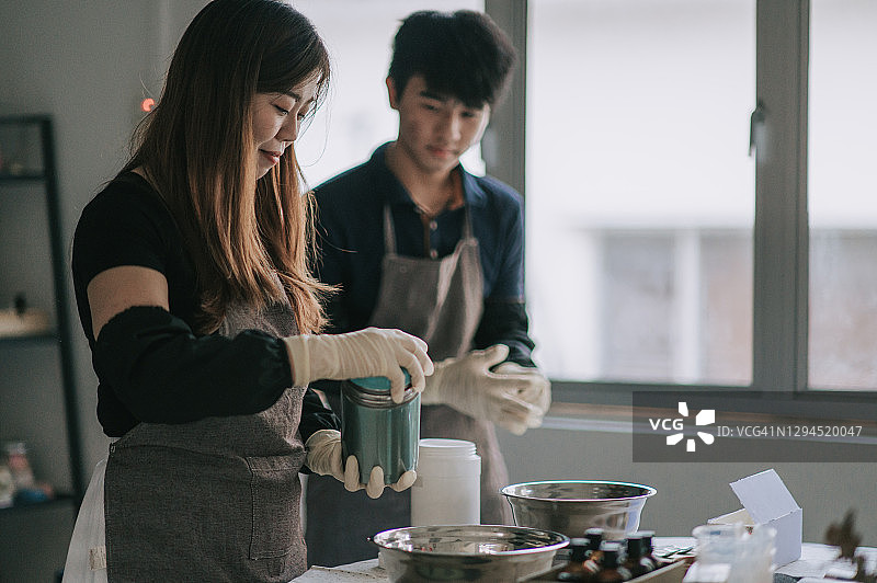 亚洲华人少年向女艺术家学习制作肥皂的过程图片素材
