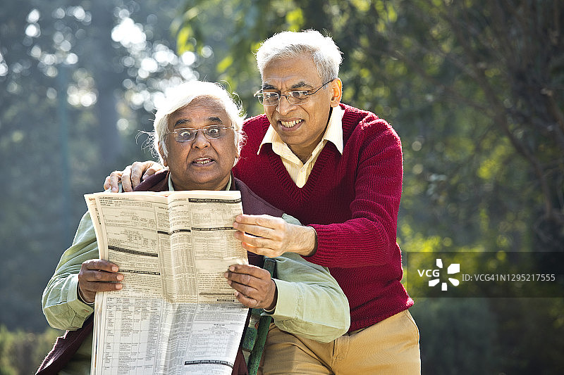 两个老人正在看报纸图片素材