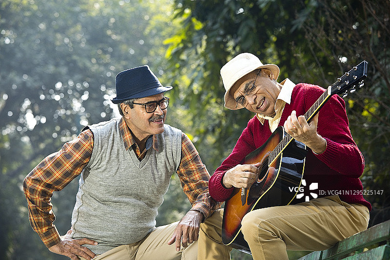 两个老人在公园玩吉他，玩得很开心图片素材