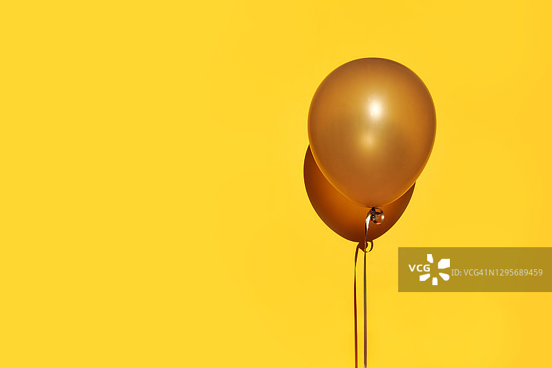 节日极简装饰气球在黄色背景与复制空间图片素材