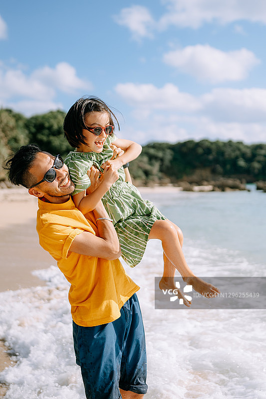 父亲和年幼的女儿在海滩上玩，日本图片素材