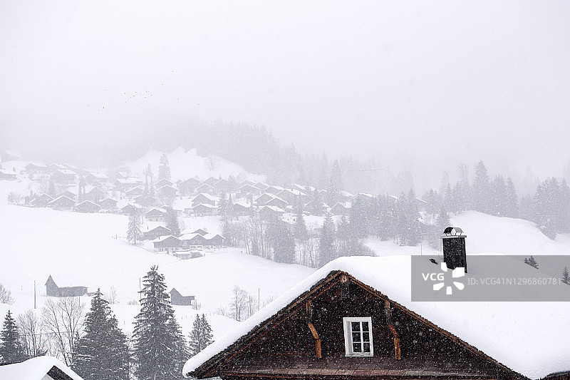 瑞士奥贝瑞贝格山上滑雪小镇的木屋上覆盖着积雪图片素材