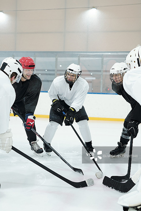 一群穿着冰鞋在溜冰场上站成一圈的职业曲棍球运动员图片素材