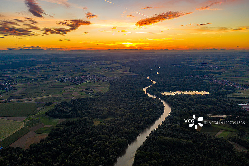 日落时河流和森林的鸟瞰图图片素材