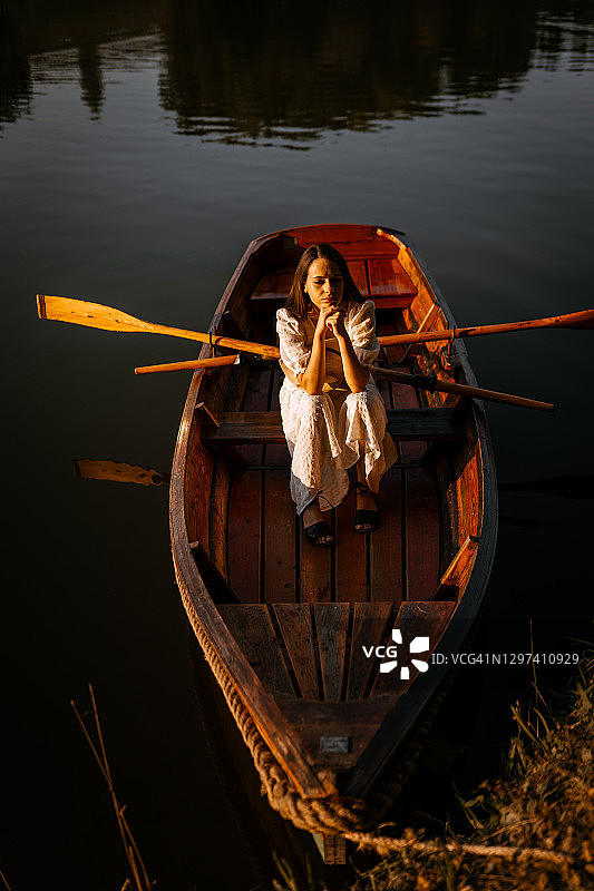 坐在湖上的独木舟里的女人图片素材