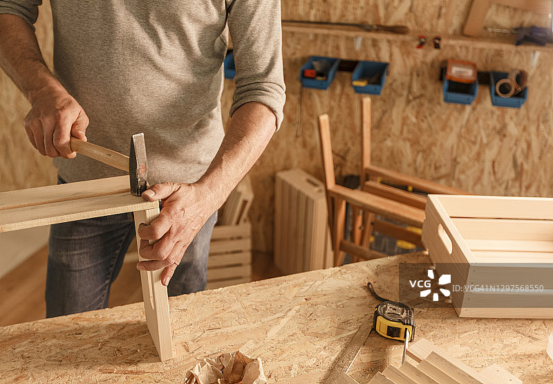 木匠把木板钉在一起，做成木箱图片素材