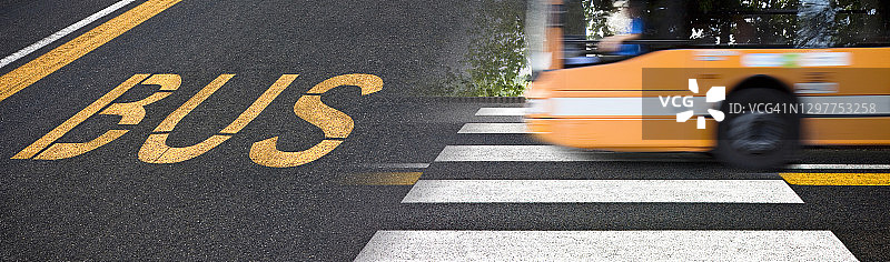 城市场景用黄色公交标志写在柏油路上，有行人过街标志和城市公交到达道路上的一个步行区-概念形象图片素材