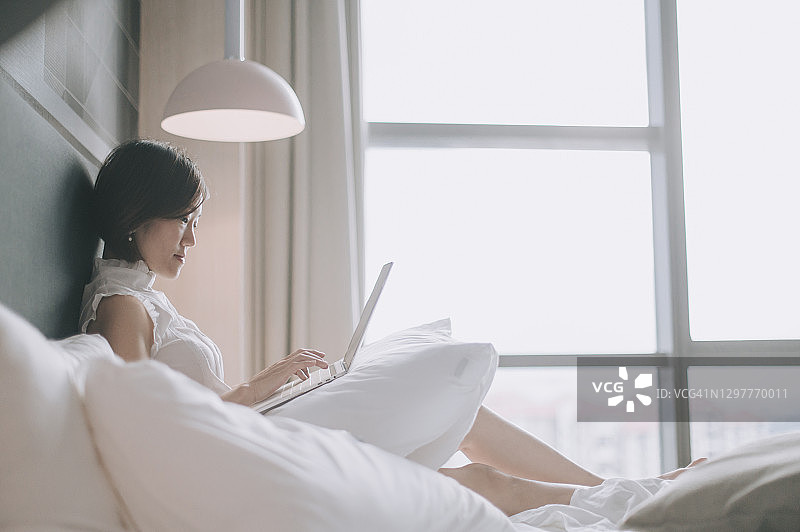 亚洲中国美女在家工作，在卧室与同事进行虚拟会议图片素材