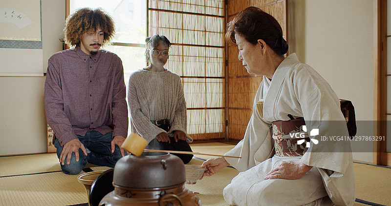 穿着和服的女主人在日本茶道上摆碗图片素材