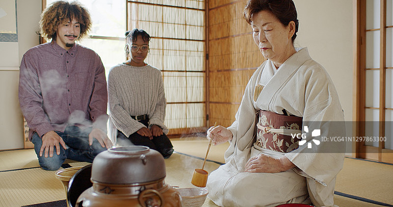外国游客在日本传统仪式上观察女主人搅茶图片素材