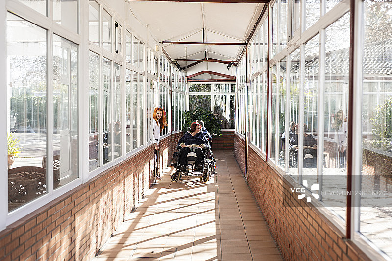 残疾男女在轮椅上由康复中心的女护士护理图片素材