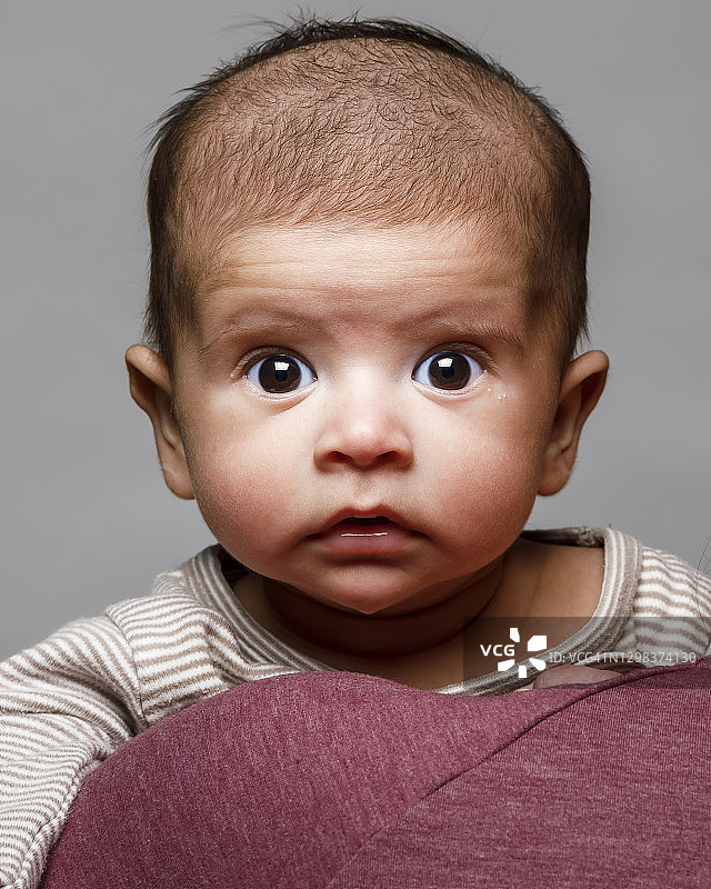 一个刚出生的男婴专注地看着相机图片素材