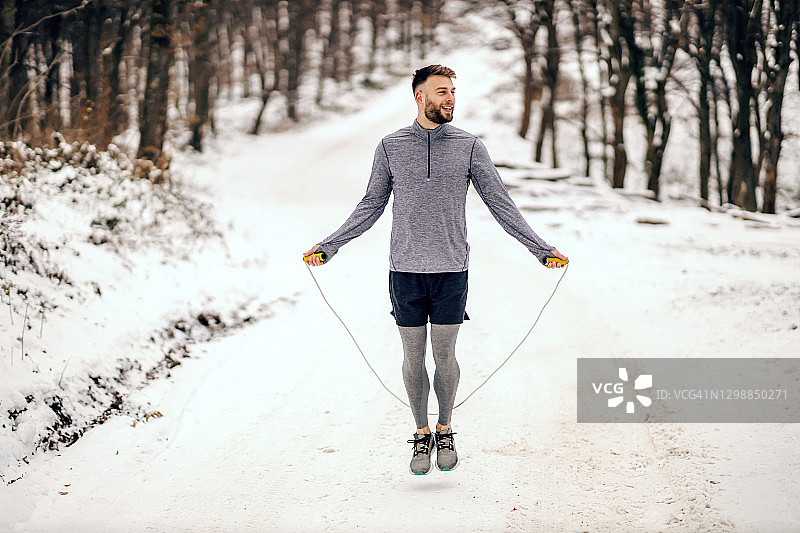 雪天，运动员在大自然中跳绳。冬季健身，健康生活，有氧运动图片素材