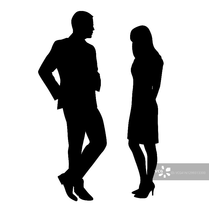 男人和女人站在一起聊天，调情。男人穿西装，女人穿短裙，靴子和高跟鞋。在工作或聚会上的会议图片素材